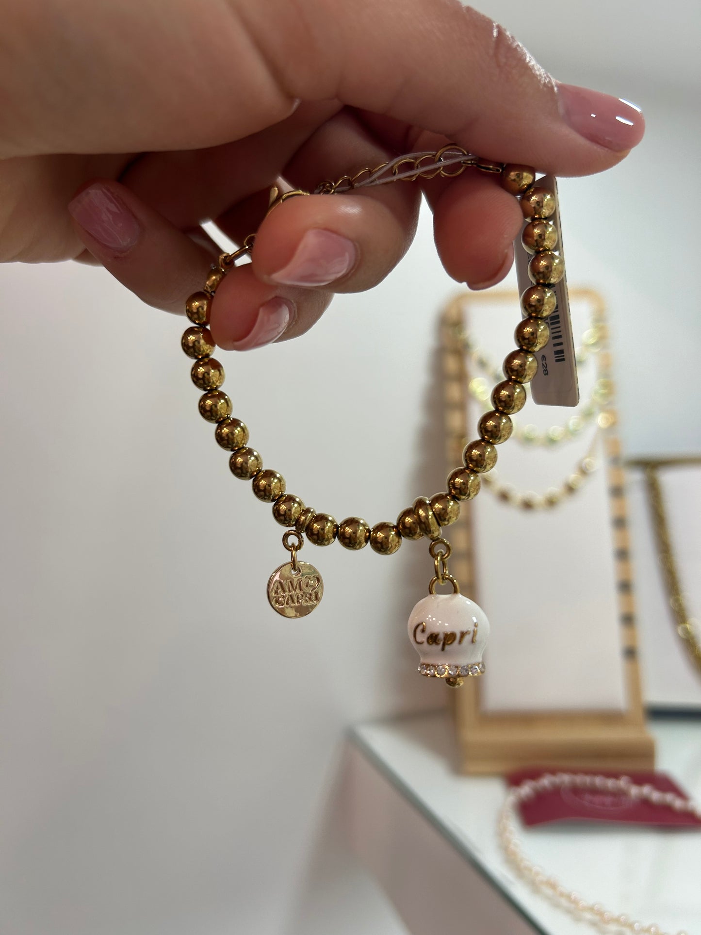 Bracciale in Acciaio a perline con campanella pendente bianca e oro con scritta Capri